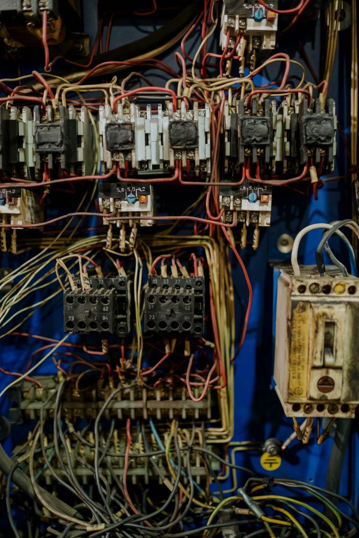 about-us-02 Close-up view of an intricate electrical wiring panel with various cables and connectors.